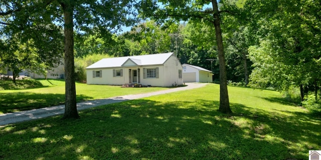 135 Phipps St, Paducah, KY 42001 - ranch-style house featuring a detached garage, a front yard, an outbuilding, and view of wooded area