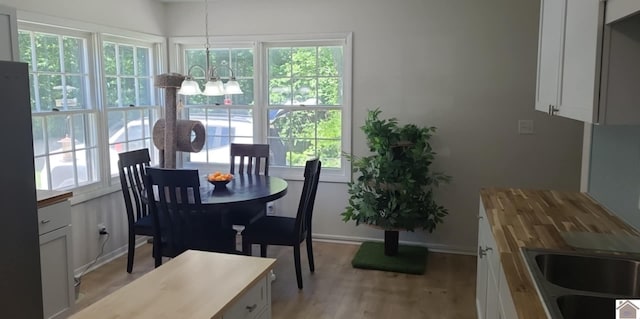 135 Phipps St, Paducah, KY 42001 - dining space with a chandelier, light wood-style flooring, and baseboards