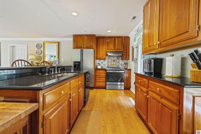 3011 Little Bear Hwy, Gilbertsville, KY 42044 - kitchen featuring stainless steel appliances, under cabinet range hood, a sink, ornamental molding, and brown cabinetry