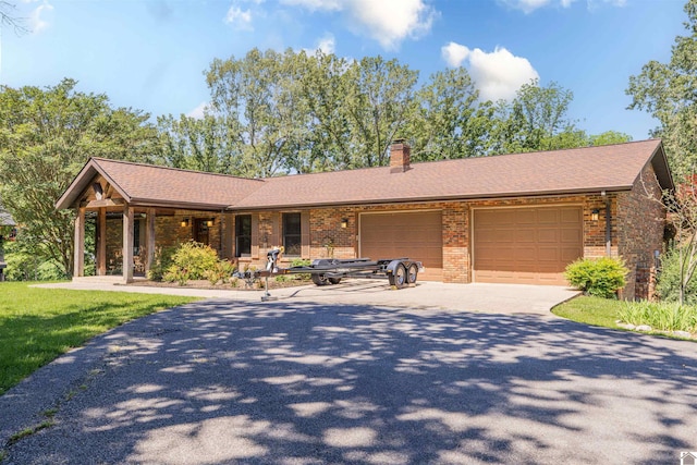 3011 Little Bear Hwy, Gilbertsville, KY 42044 - view of front of property with a garage, brick siding, driveway, a chimney, and roof with shingles