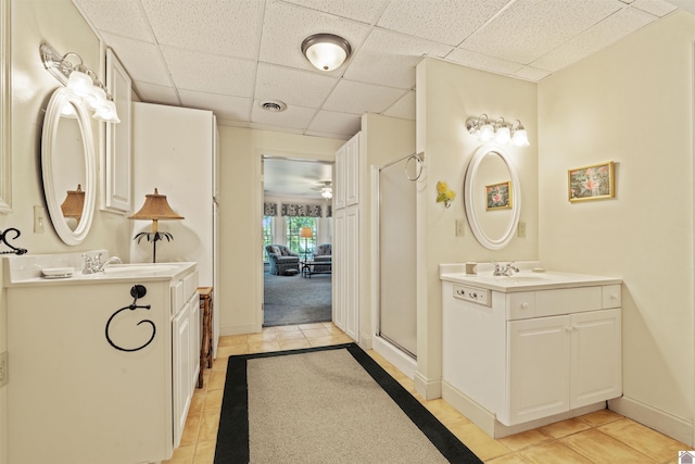 3011 Little Bear Hwy, Gilbertsville, KY 42044 - bathroom featuring a paneled ceiling, tile patterned floors, two vanities, a stall shower, and baseboards