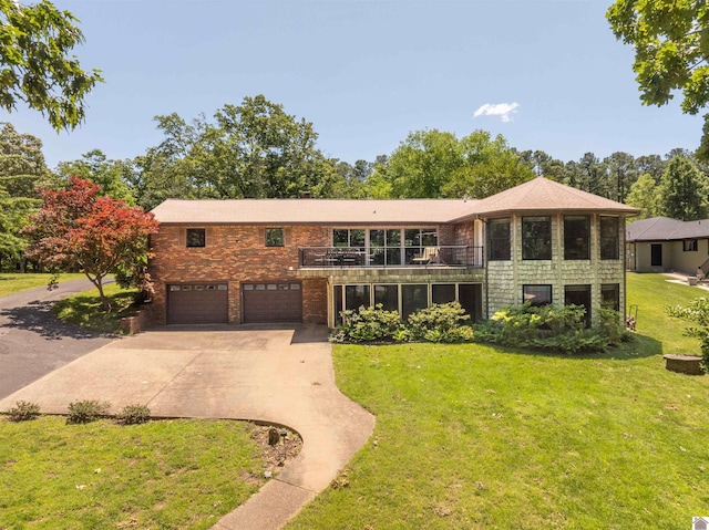3011 Little Bear Hwy, Gilbertsville, KY 42044 - view of front of house featuring concrete driveway, an attached garage, a front yard, a balcony, and brick siding