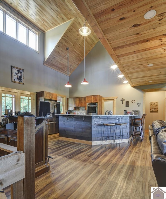 3210 Douglas Rd, Murray, KY 42071 - kitchen featuring stainless steel appliances, high vaulted ceiling, wood ceiling with exposed beams, brown cabinetry, and wood finished floors