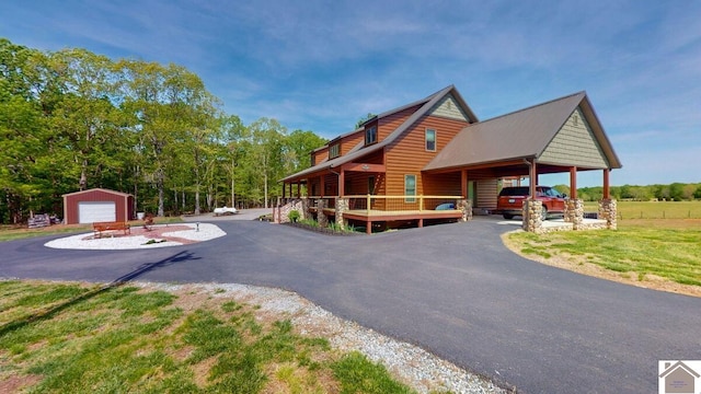 3210 Douglas Rd, Murray, KY 42071 - view of front of property featuring faux log siding, a detached garage, a carport, and asphalt driveway
