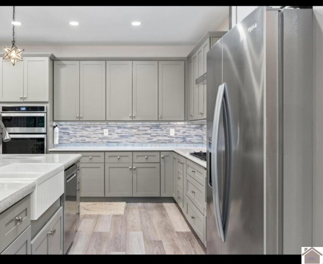 34 Navajo Ct, Cadiz, KY 42211 - kitchen with appliances with stainless steel finishes, gray cabinetry, light wood finished floors, light countertops, and backsplash
