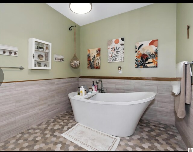 34 Navajo Ct, Cadiz, KY 42211 - bathroom featuring tile walls, a freestanding tub, a wainscoted wall, and tile patterned floors