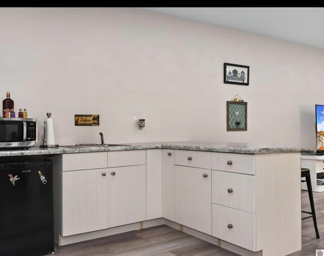 34 Navajo Ct, Cadiz, KY 42211 - kitchen featuring fridge, stainless steel microwave, a sink, a kitchen breakfast bar, and light wood-style floors