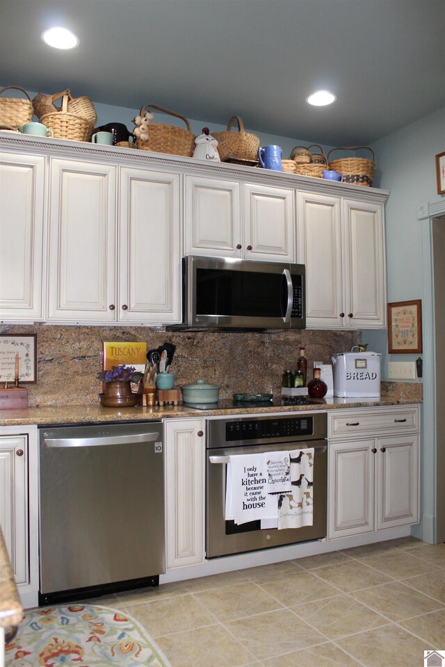 395 Wildcat Trce, Paducah, KY 42003 - kitchen featuring stainless steel appliances, tasteful backsplash, light tile patterned floors, recessed lighting, and light stone countertops