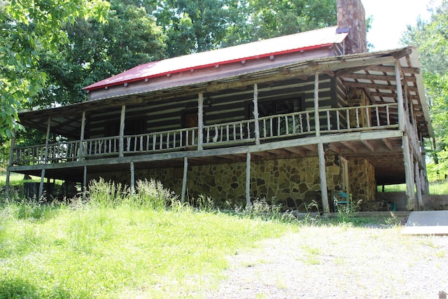 2365 Weldon Rd, Marion, KY 42064 - view of front facade with log siding, metal roof, a chimney, and stone siding
