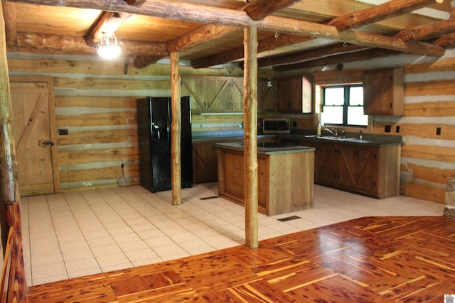 2365 Weldon Rd, Marion, KY 42064 - kitchen featuring dark countertops, black fridge with ice dispenser, stainless steel microwave, wooden walls, and beam ceiling