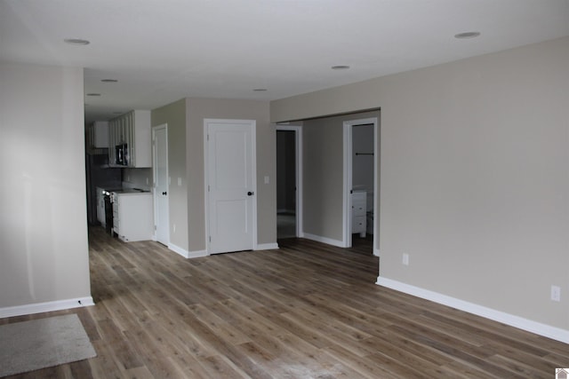 1400 Walnut St, Benton, KY 42025 - unfurnished living room with baseboards, wood finished floors, and recessed lighting