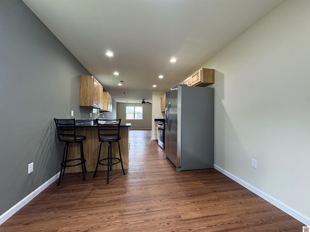 110 Dawson Rd, Princeton, KY 42445 - kitchen with freestanding refrigerator, a peninsula, recessed lighting, dark wood finished floors, and a kitchen breakfast bar