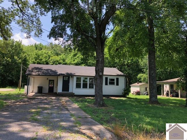 181 W 3rd St, Calvert City, KY 42029 - ranch-style house featuring asphalt driveway, a front lawn, and an attached carport