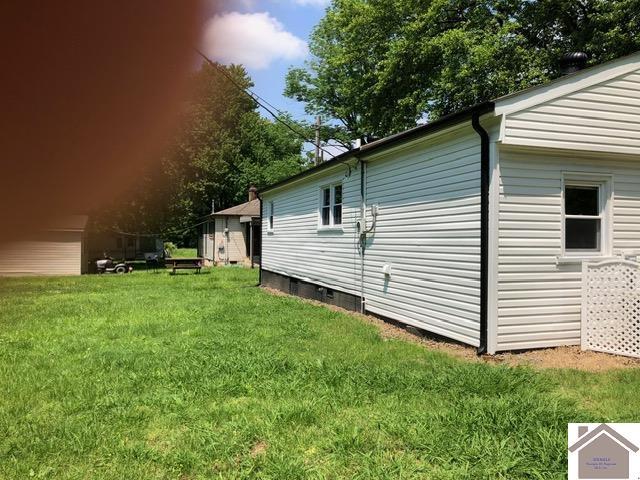 181 W 3rd St, Calvert City, KY 42029 - view of property exterior with a yard and crawl space