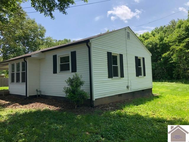 181 W 3rd St, Calvert City, KY 42029 - view of home's exterior featuring crawl space and a lawn