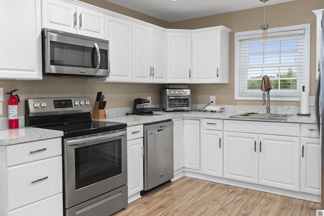 99 Jacey Blake Dr, Calvert City, KY 42029 - kitchen with appliances with stainless steel finishes, a sink, white cabinets, and light countertops