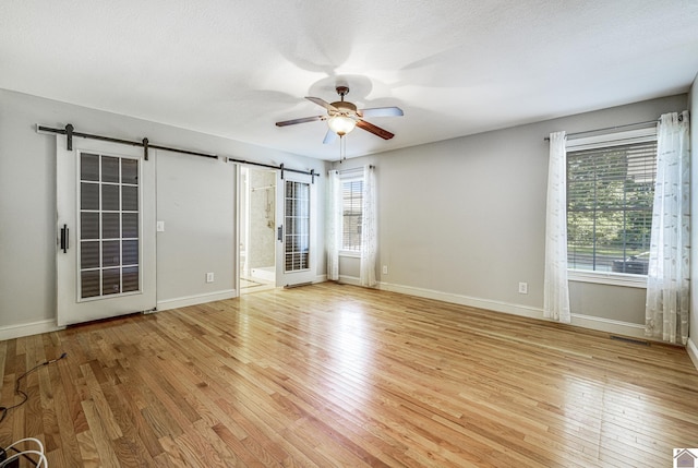 54 Grove Ln, Murray, KY 42071 - spare room featuring a barn door, a ceiling fan, and light wood-style flooring