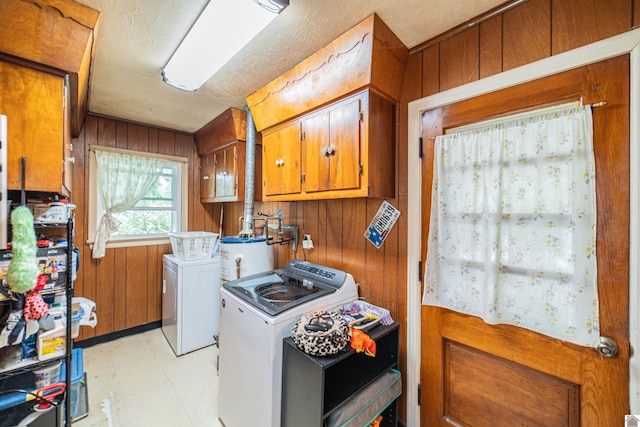 650 Cypress Cir, Calvert City, KY 42029 - laundry room featuring separate washer and dryer, light floors, gas water heater, wooden walls, and cabinet space