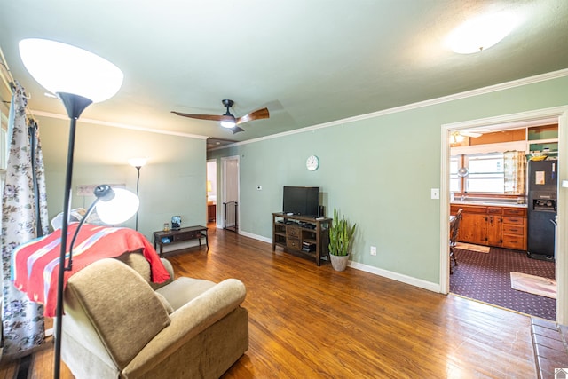 650 Cypress Cir, Calvert City, KY 42029 - living area featuring wood finished floors, ornamental molding, baseboards, and a ceiling fan