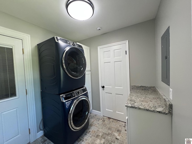 802 S 17th St, Murray, KY 42071 - laundry area with stacked washer and clothes dryer, electric panel, baseboards, brick patterned floors, and cabinet space