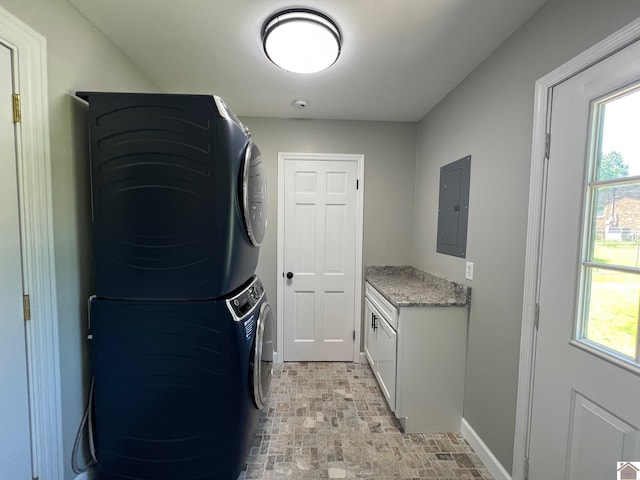 802 S 17th St, Murray, KY 42071 - laundry area with electric panel, stacked washing machine and dryer, cabinet space, baseboards, and brick patterned floors