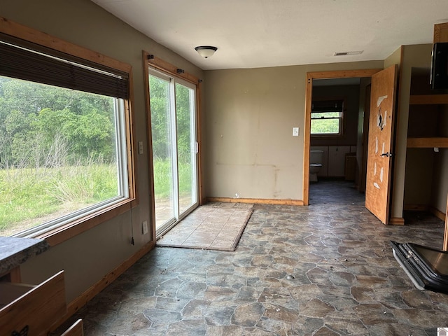 1251 Tater Rd, Mayfield, KY 42066 - unfurnished dining area with stone finish floors, baseboards, and healthy amount of natural light