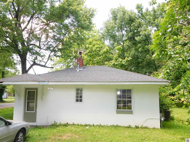 2837 Tennessee, Paducah, KY 42003 - view of side of property with a shingled roof, a chimney, concrete block siding, and a yard