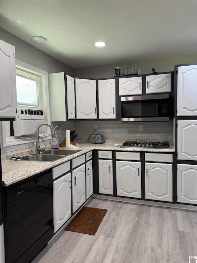 7740 Old Mayfield Rd, Paducah, KY 42003 - kitchen with appliances with stainless steel finishes, a sink, decorative backsplash, light countertops, and light wood-type flooring