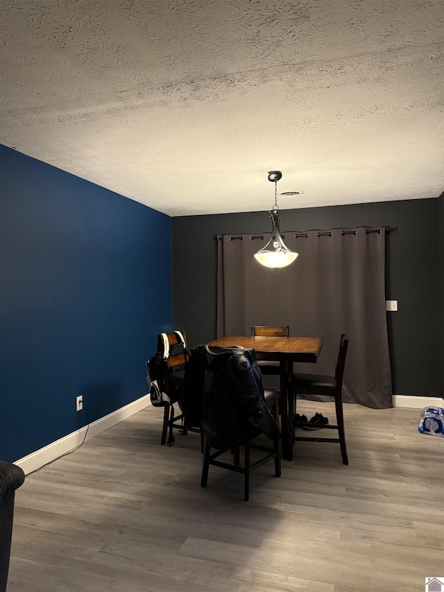 7740 Old Mayfield Rd, Paducah, KY 42003 - dining space featuring a textured ceiling, light wood-style floors, and baseboards