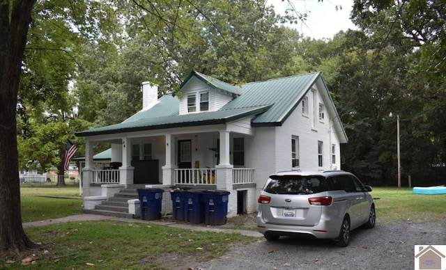 922 S 27th St, Paducah, KY 42003 - view of front of property featuring covered porch, driveway, a chimney, metal roof, and a front yard