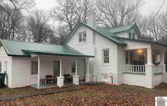 922 S 27th St, Paducah, KY 42003 - back of house with covered porch, brick siding, a chimney, and metal roof