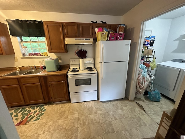 535 Leeds Dr, Paducah, KY 42003 - kitchen with white appliances, under cabinet range hood, a sink, washer / clothes dryer, and brown cabinetry
