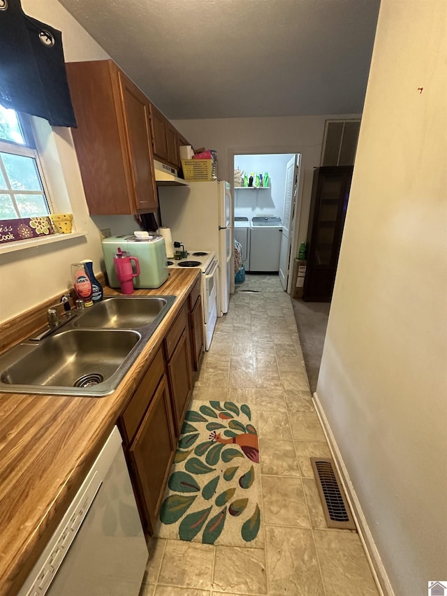 535 Leeds Dr, Paducah, KY 42003 - kitchen featuring a sink, separate washer and dryer, white appliances, under cabinet range hood, and brown cabinets