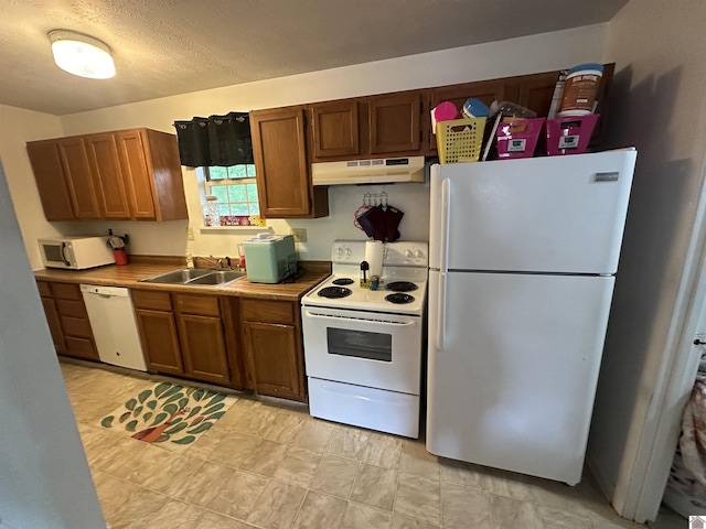 535 Leeds Dr, Paducah, KY 42003 - kitchen featuring white appliances, under cabinet range hood, a sink, and brown cabinets