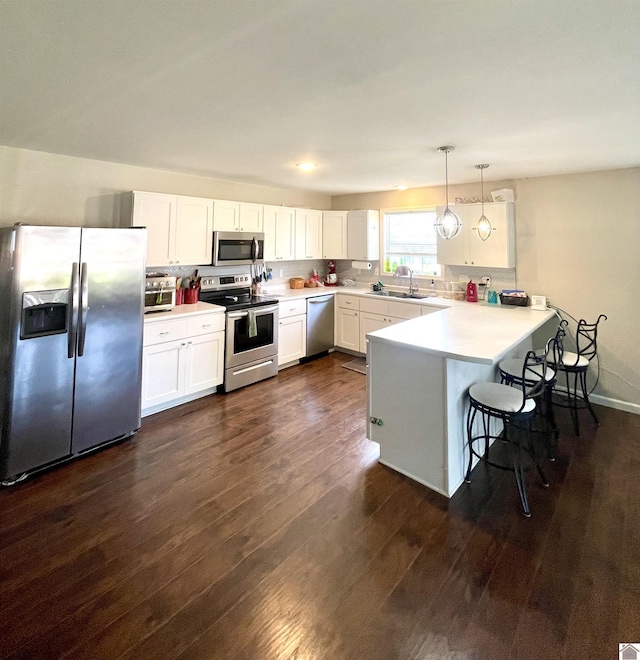 1783 Radio Rd, Almo, KY 42020 - kitchen with appliances with stainless steel finishes, dark wood-type flooring, a sink, a peninsula, and white cabinetry