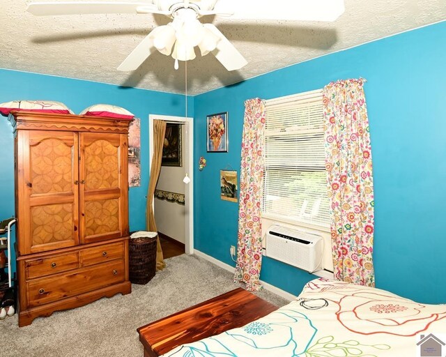 250 Jan Ann Dr, Paducah, KY 42003 - bedroom with a wall unit AC, ceiling fan, baseboards, a textured ceiling, and carpet floors