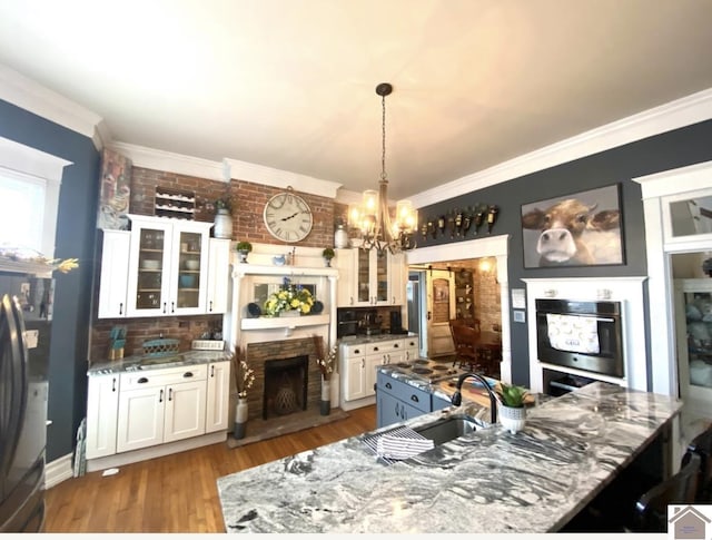 1722 Jefferson St, Paducah, KY 42001 - kitchen with freestanding refrigerator, a chandelier, a large island, white cabinetry, and a sink