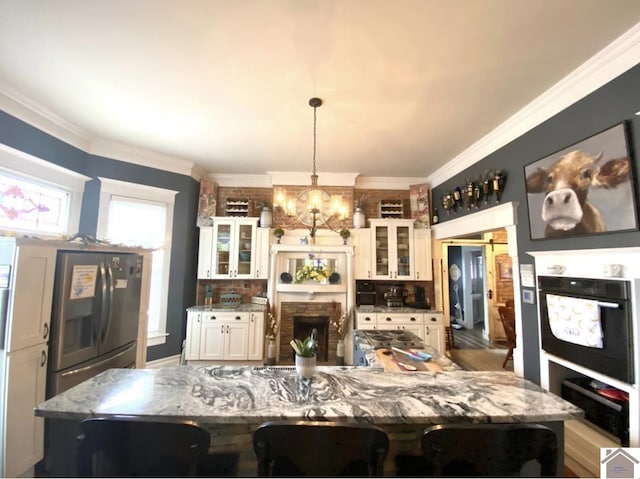 1722 Jefferson St, Paducah, KY 42001 - kitchen with black oven, a chandelier, a large island, crown molding, and white cabinets
