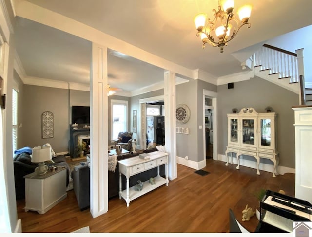 1722 Jefferson St, Paducah, KY 42001 - living room featuring dark wood-style floors, crown molding, a chandelier, stairway, and baseboards