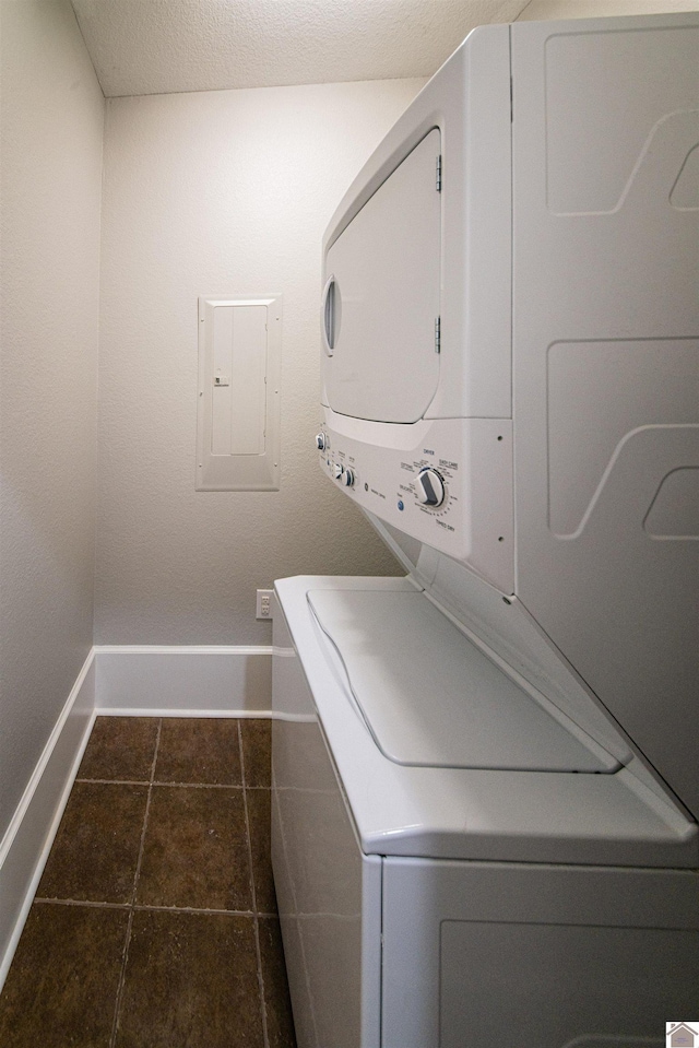 620 Madison St, Paducah, KY 42001 - washroom featuring estacked washer and dryer, baseboards, electric panel, and dark tile patterned floors