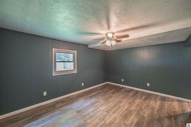 9740 Crotzer Rd, West Paducah, KY 42086 - empty room with ceiling fan, hardwood / wood-style flooring, a textured ceiling, baseboards, and wood walls