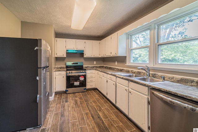 9740 Crotzer Rd, West Paducah, KY 42086 - kitchen featuring appliances with stainless steel finishes, a sink, under cabinet range hood, a textured ceiling, and white cabinetry
