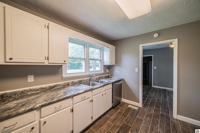 9740 Crotzer Rd, West Paducah, KY 42086 - kitchen featuring dishwasher, a sink, baseboards, white cabinets, and a textured ceiling