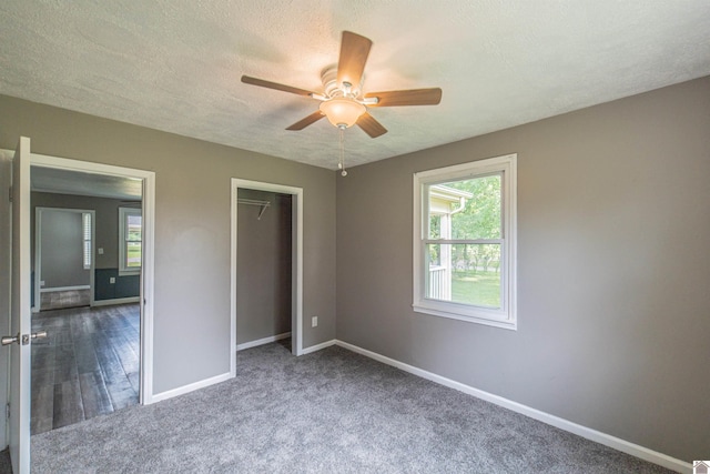 9740 Crotzer Rd, West Paducah, KY 42086 - unfurnished bedroom featuring multiple windows, baseboards, carpet flooring, a closet, and a textured ceiling