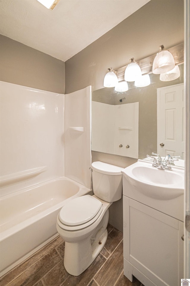 9740 Crotzer Rd, West Paducah, KY 42086 - bathroom with toilet, vanity, wood finished floors, and bathtub / shower combination