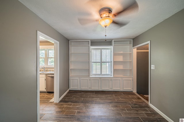 9740 Crotzer Rd, West Paducah, KY 42086 - empty room with wood tiled floors, ceiling fan, a textured ceiling, a sink, and baseboards