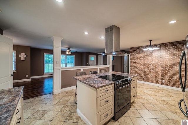 3561 Beal, Hardin, KY 42048 - kitchen with range with electric cooktop, island exhaust hood, ceiling fan, brick wall, and dark stone countertops