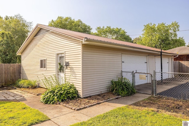 2145 Blankenship, Paducah, KY 42003 - view of side of home with a detached garage, a metal roof, and a gate