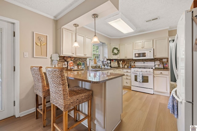 2145 Blankenship, Paducah, KY 42003 - kitchen with white appliances, a peninsula, light wood-type flooring, tasteful backsplash, and a kitchen breakfast bar
