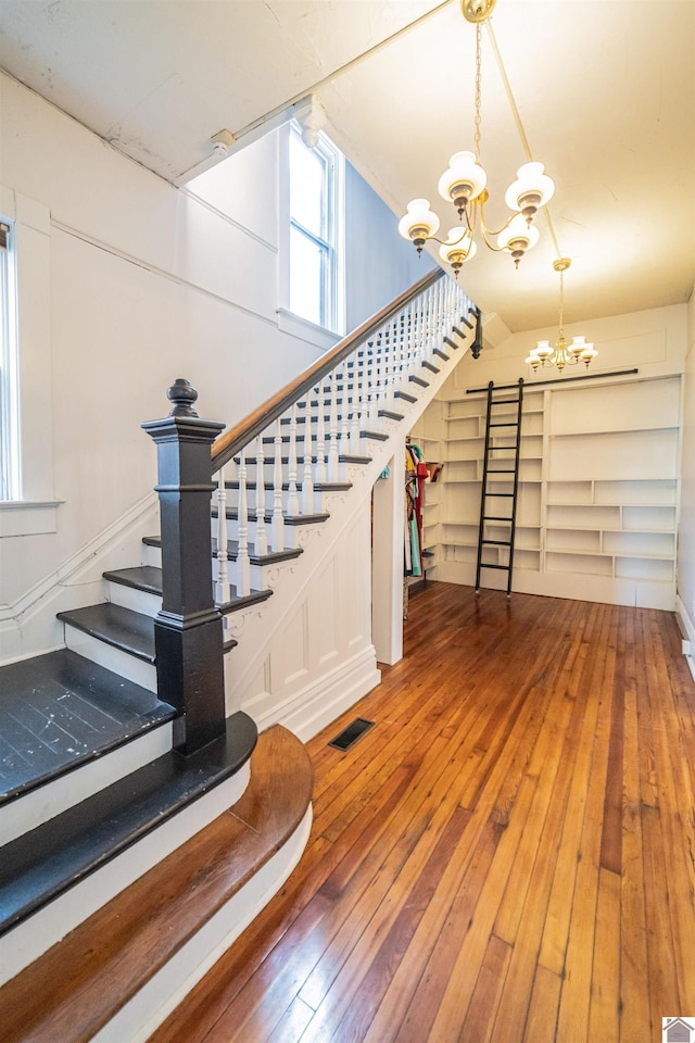 326 N 9th, Paducah, KY 42001 - stairway with a chandelier, wood-type flooring, a barn door, and lofted ceiling
